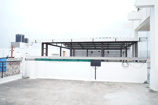 Wide rooftop view showing a metal-framed pergola above the parapet