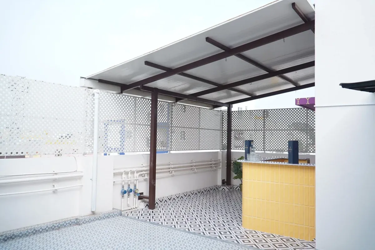 Single-slope PUF roof beside a terrace room, showing the white panel underside and dark metal framing