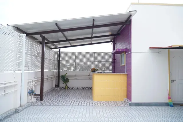 Compact single-slope roof beside a terrace room and yellow parapet