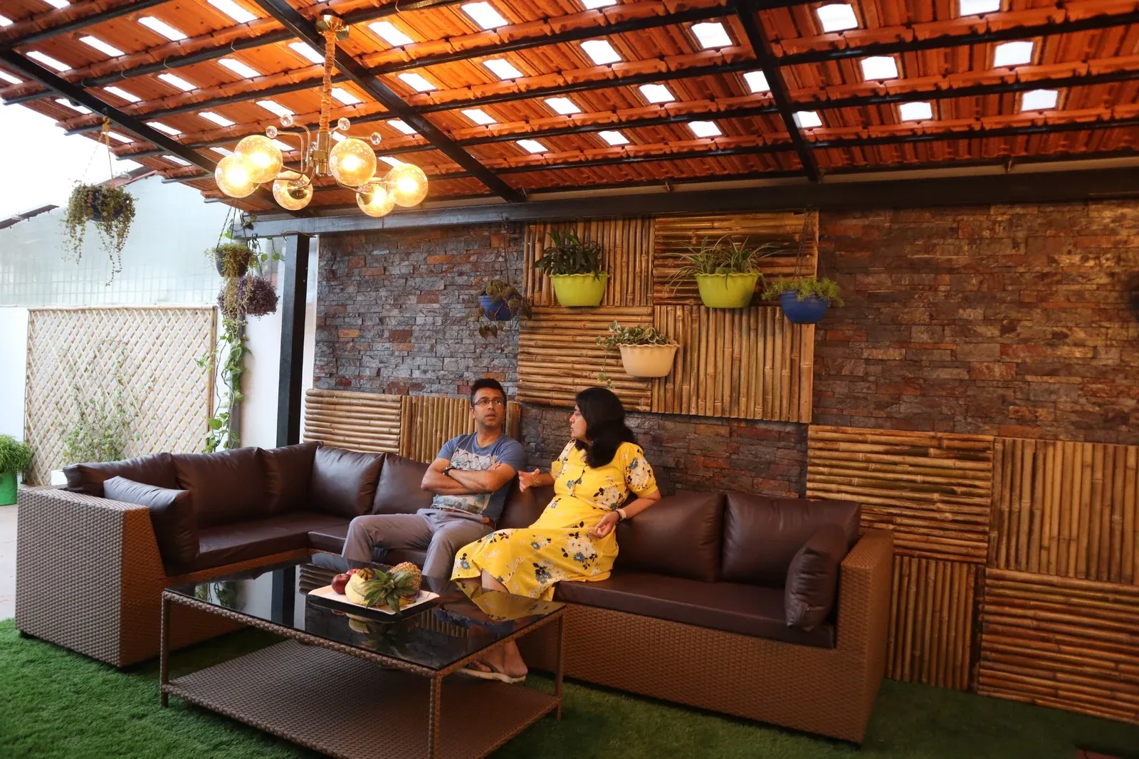 Couple relaxing on a brown sofa beneath a premium terracotta tile pergola