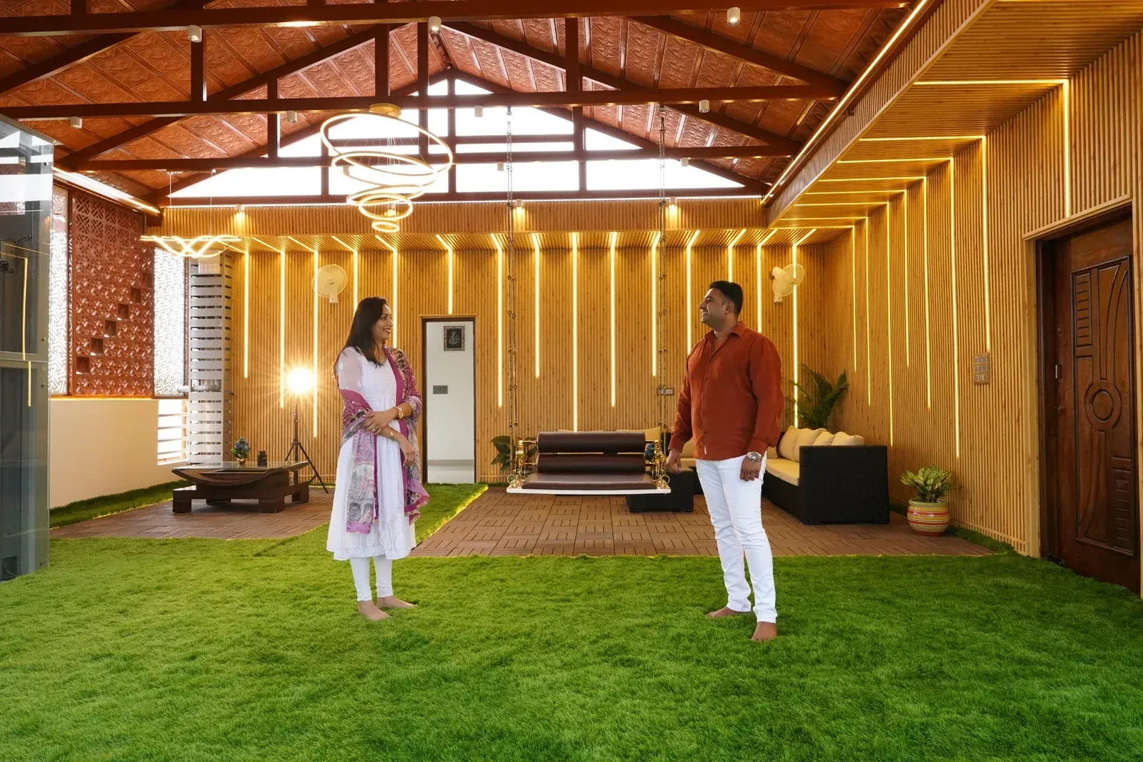 Two people standing beneath an illuminated Premium Mangalore tile pergola