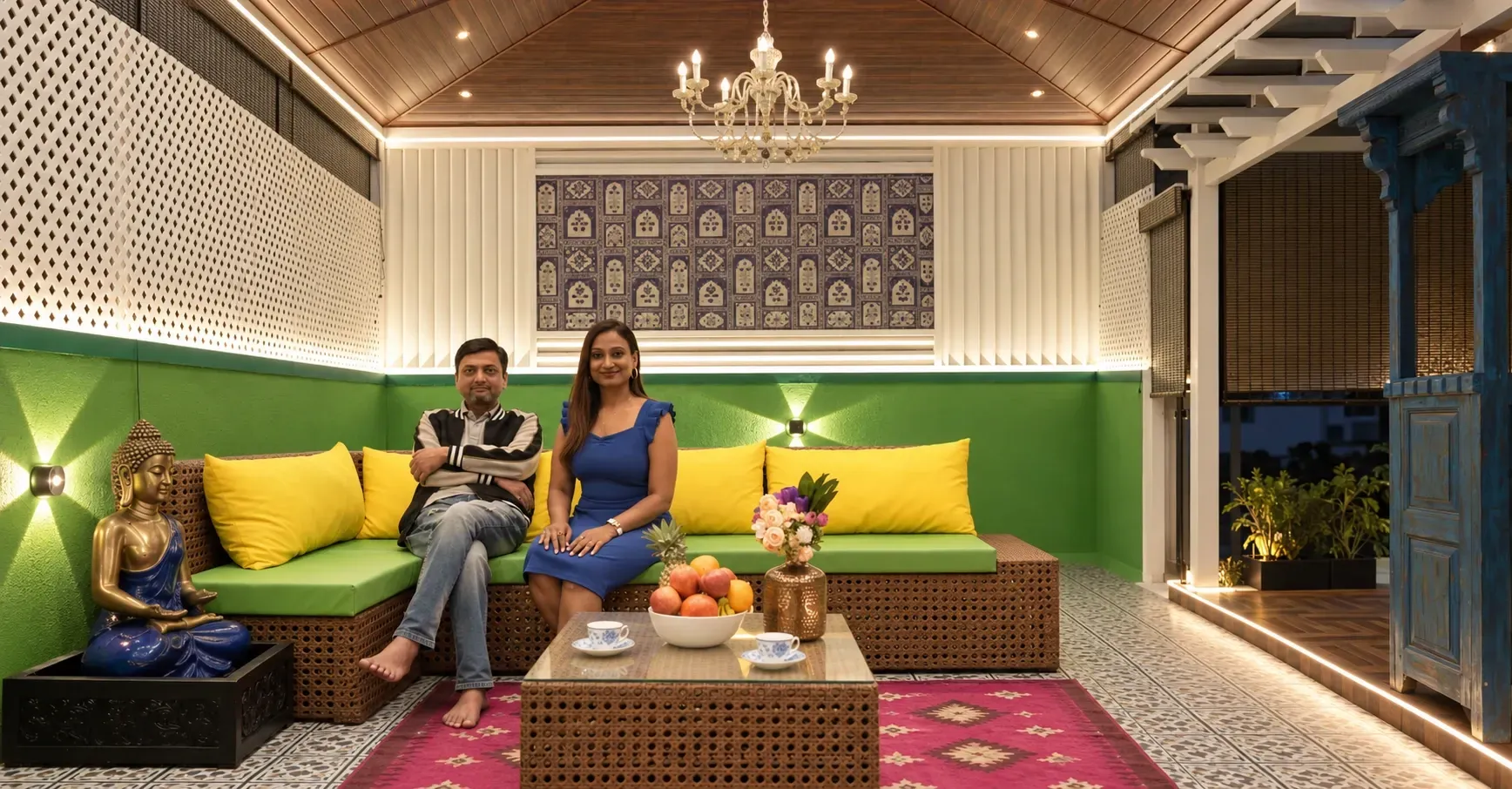 Couple seated in a warmly lit covered terrace lounge with lattice privacy screens