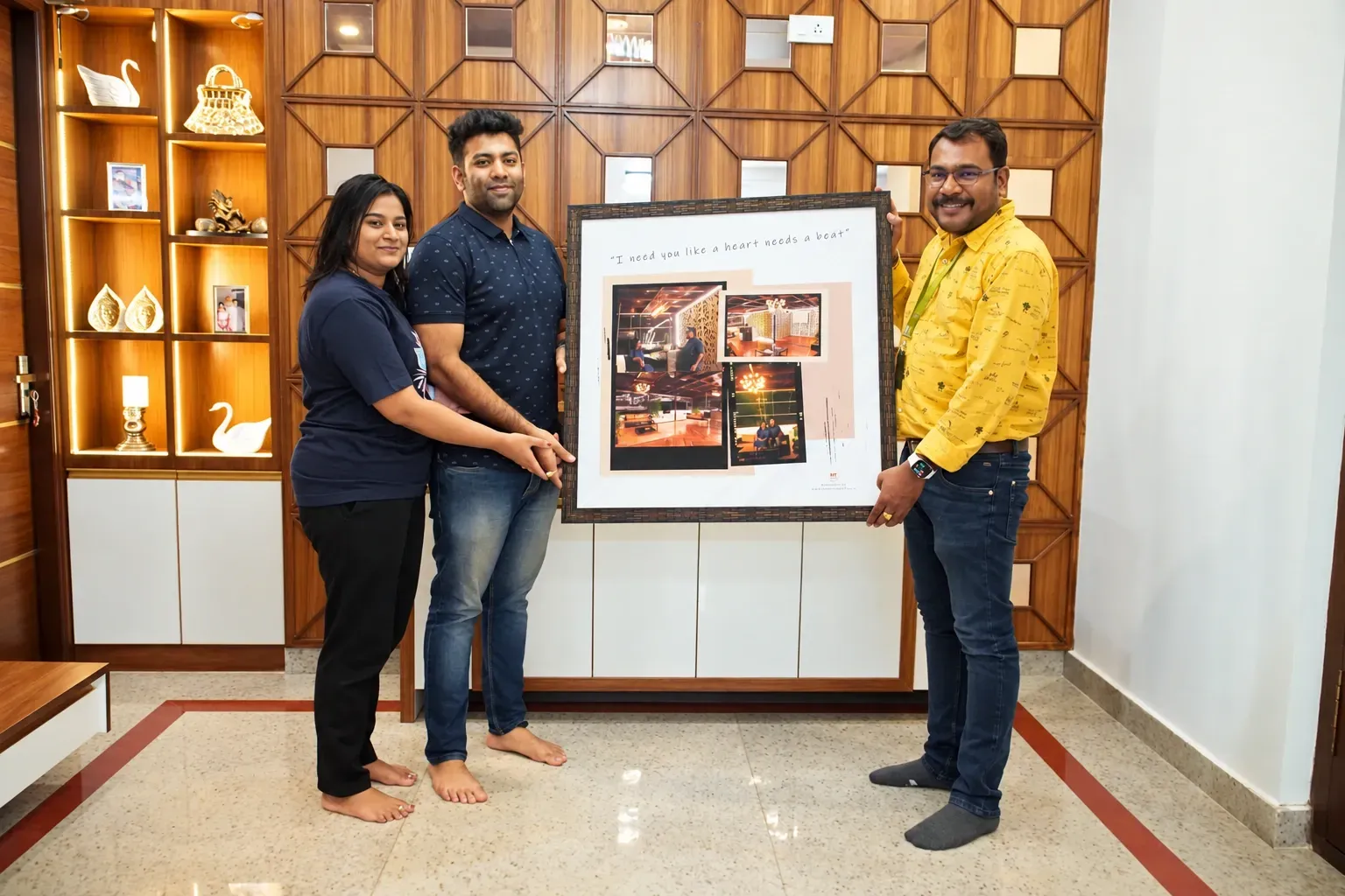 Three people holding framed project artwork during a customer handover
