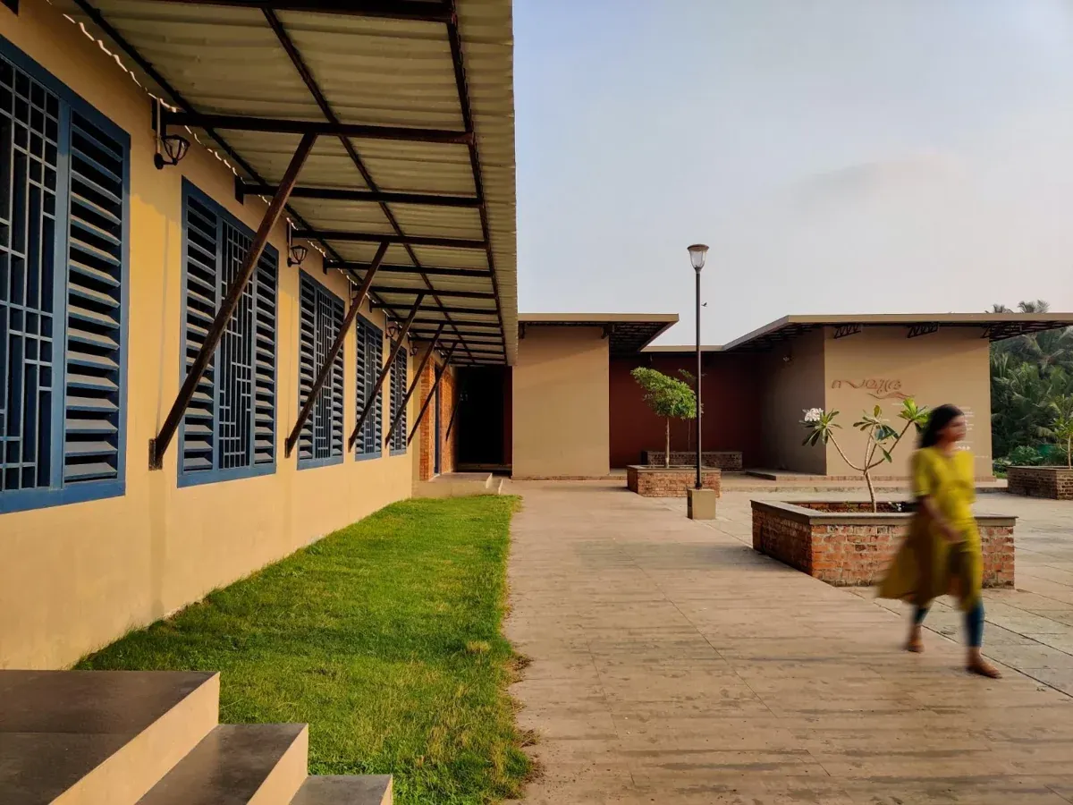 A long covered walkway beside a building with a sloping metal roof and supporting posts