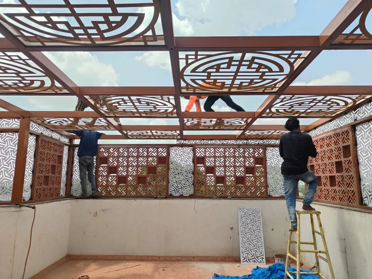 Installation team working on the premium pergola frame, roof and decorative privacy panels