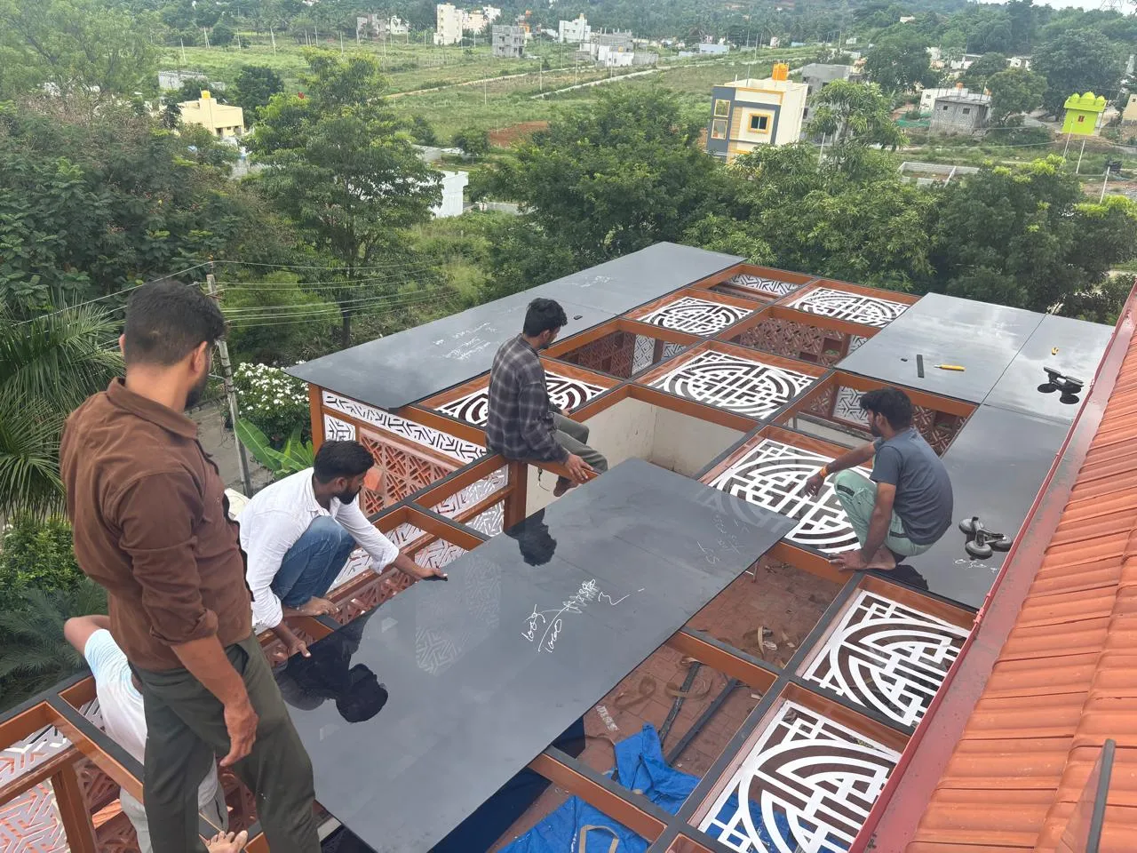 Premium Pergola installation team positioning roof panels on the metal structure at a project site
